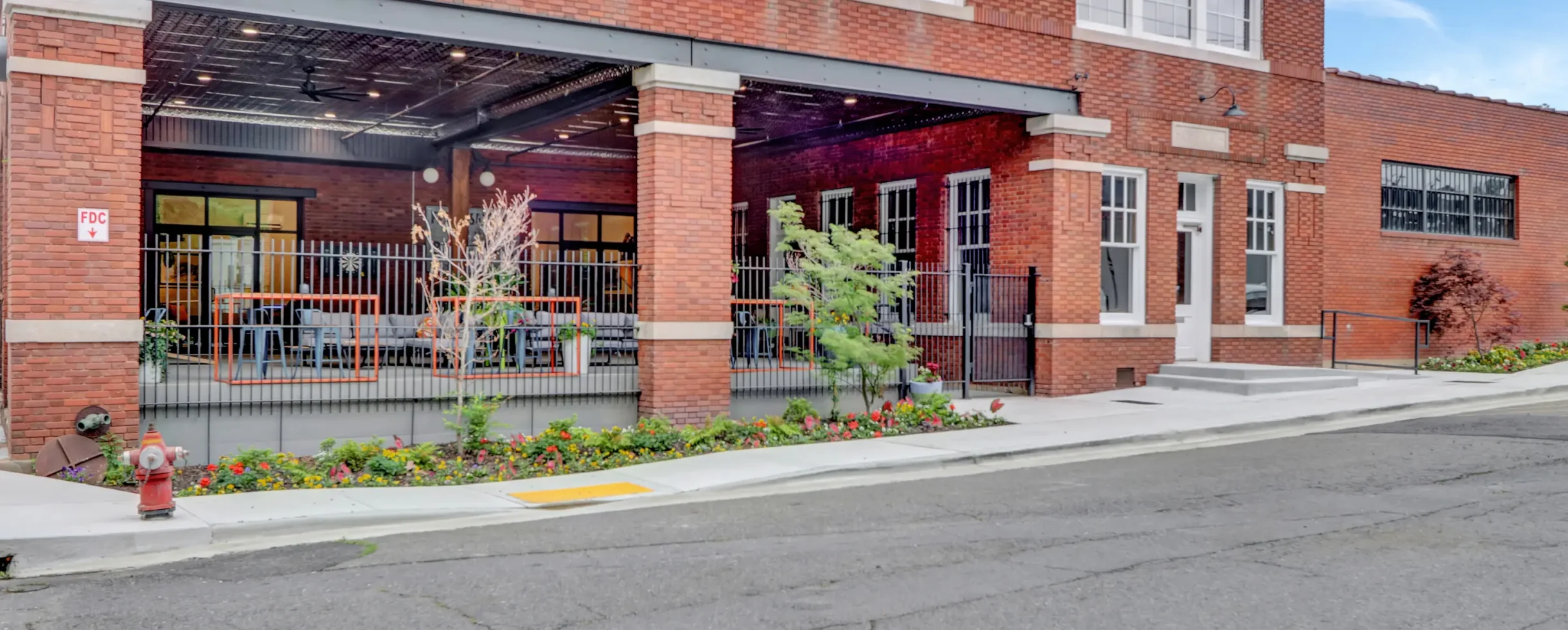 Front elevation of Lofts at Creek Street showing the historic brick design, covered patio area, and surrounding downtown streetscape