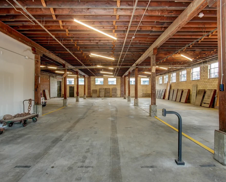 Spacious indoor parking area inside the historic Lofts at Creek Street building, featuring original beams and industrial architecture