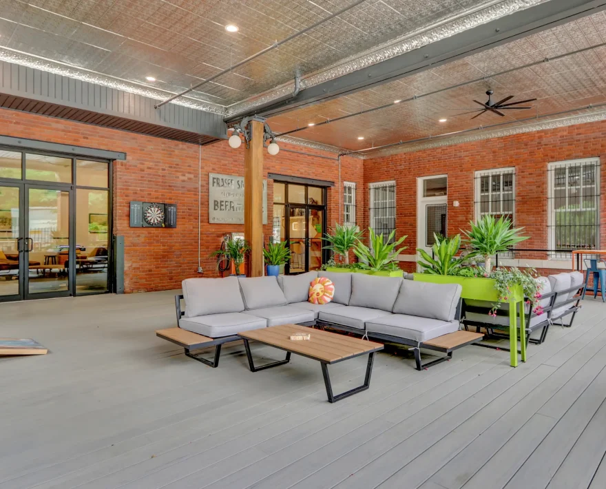 Covered open-air patio for guests at a renovated historic hotel in Hot Springs, featuring modern lounge seating and industrial architectural details