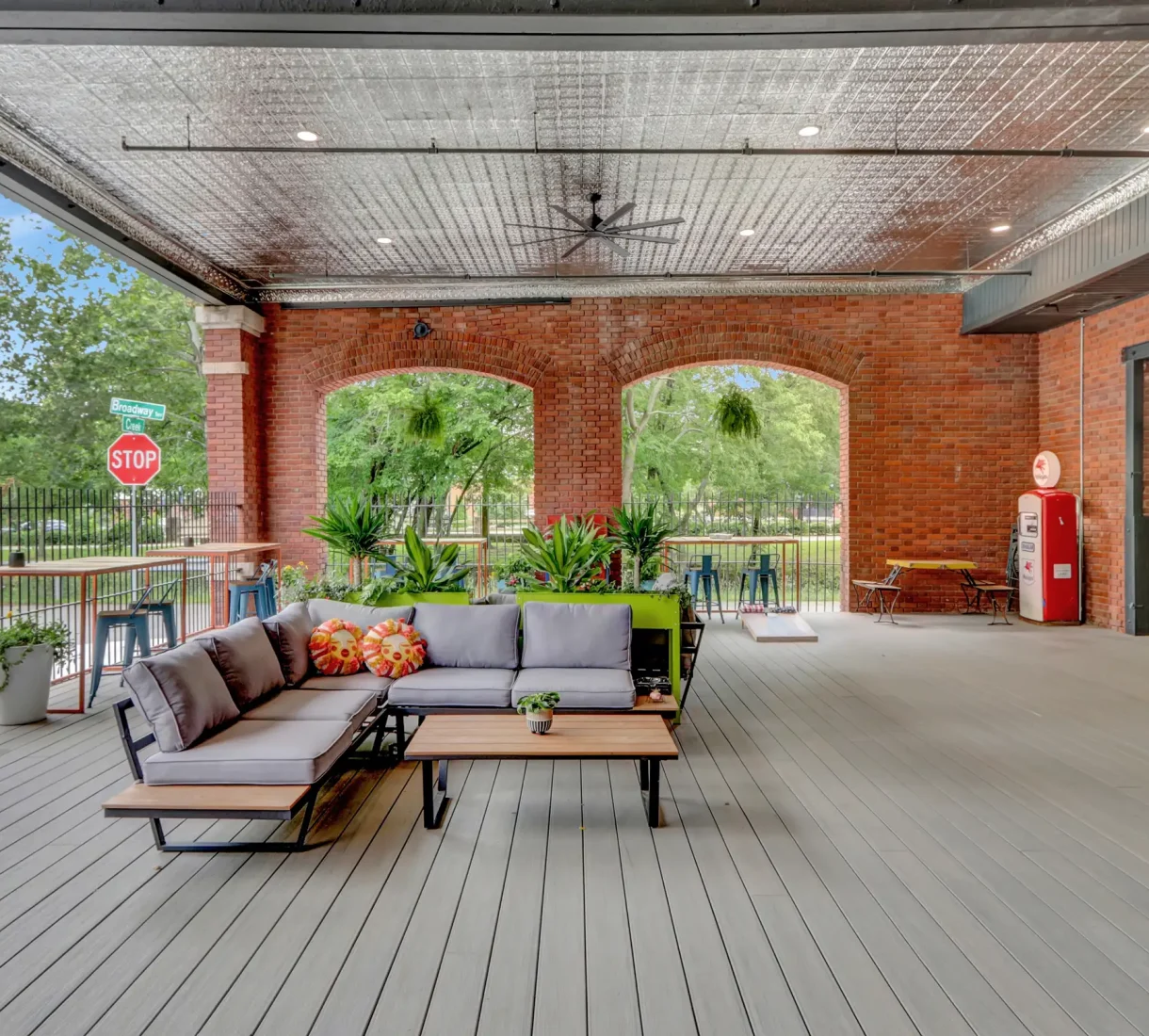 Hotel outdoor lounge area in a converted historic building, with sectional seating and bar-height tables for guest relaxation