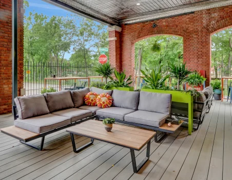 Guest relaxation patio at a boutique Hot Springs hotel, featuring modern sectional seating and greenery within a restored brick structure
