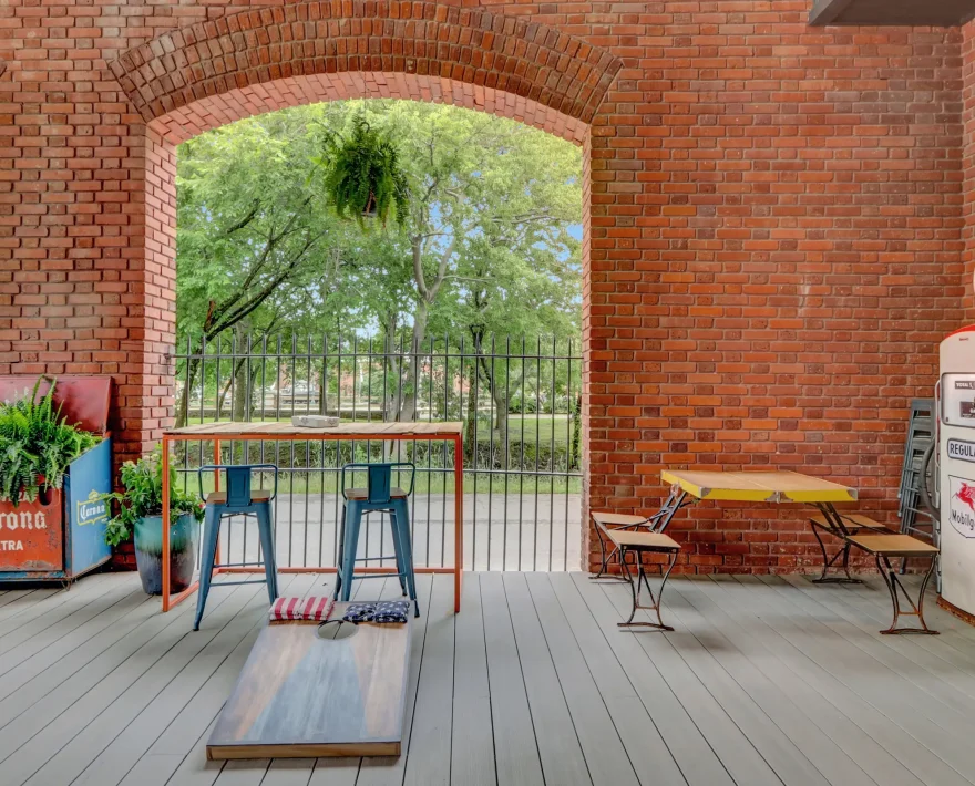 Open-air common area featuring vintage décor, guest seating, and yard games inside a renovated historic lodging property