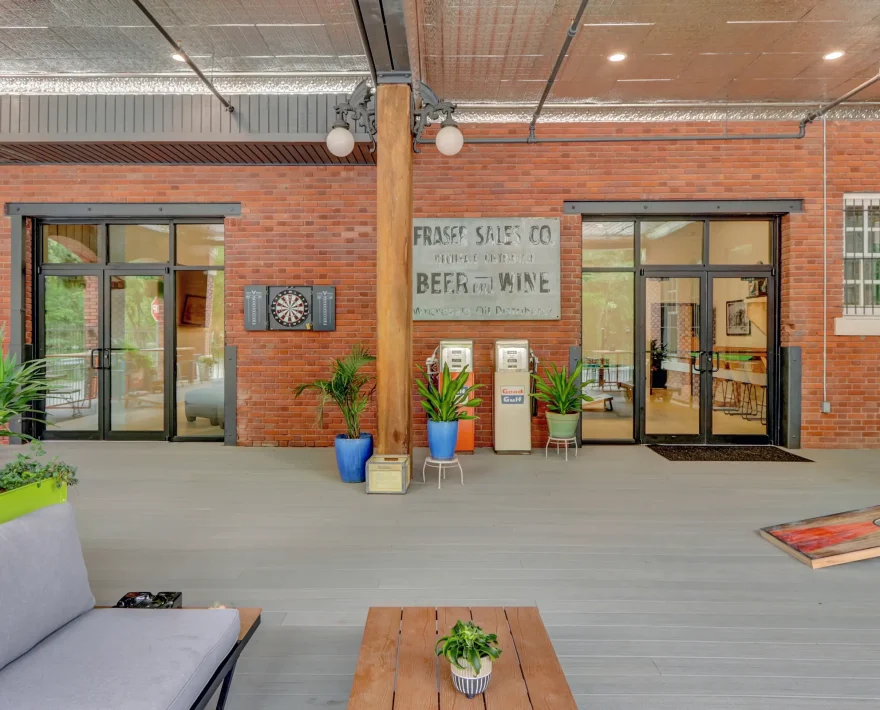 Open-air common area displaying vintage signage, plants, and guest seating inside a converted historic warehouse-style stay