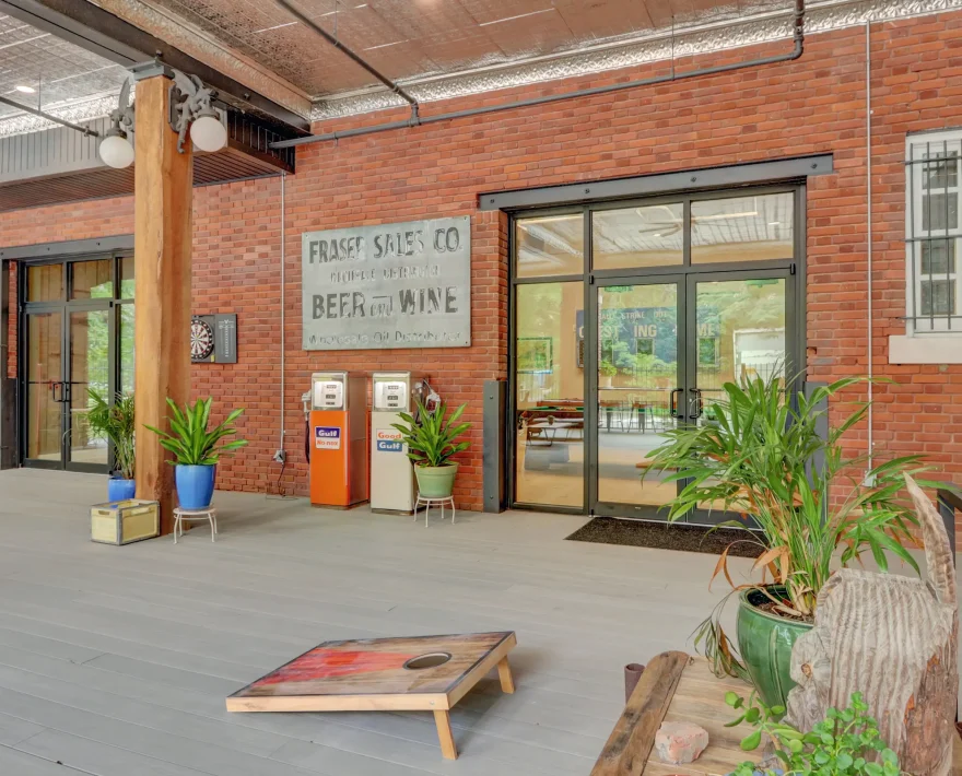 Comfortable sectional seating and planters in a loft-style accommodation’s outdoor lounge framed by brick archways