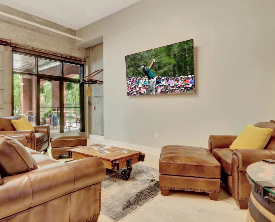Comfortable leather lounge area with large-screen TV inside a boutique lodging property converted from a historic brick building