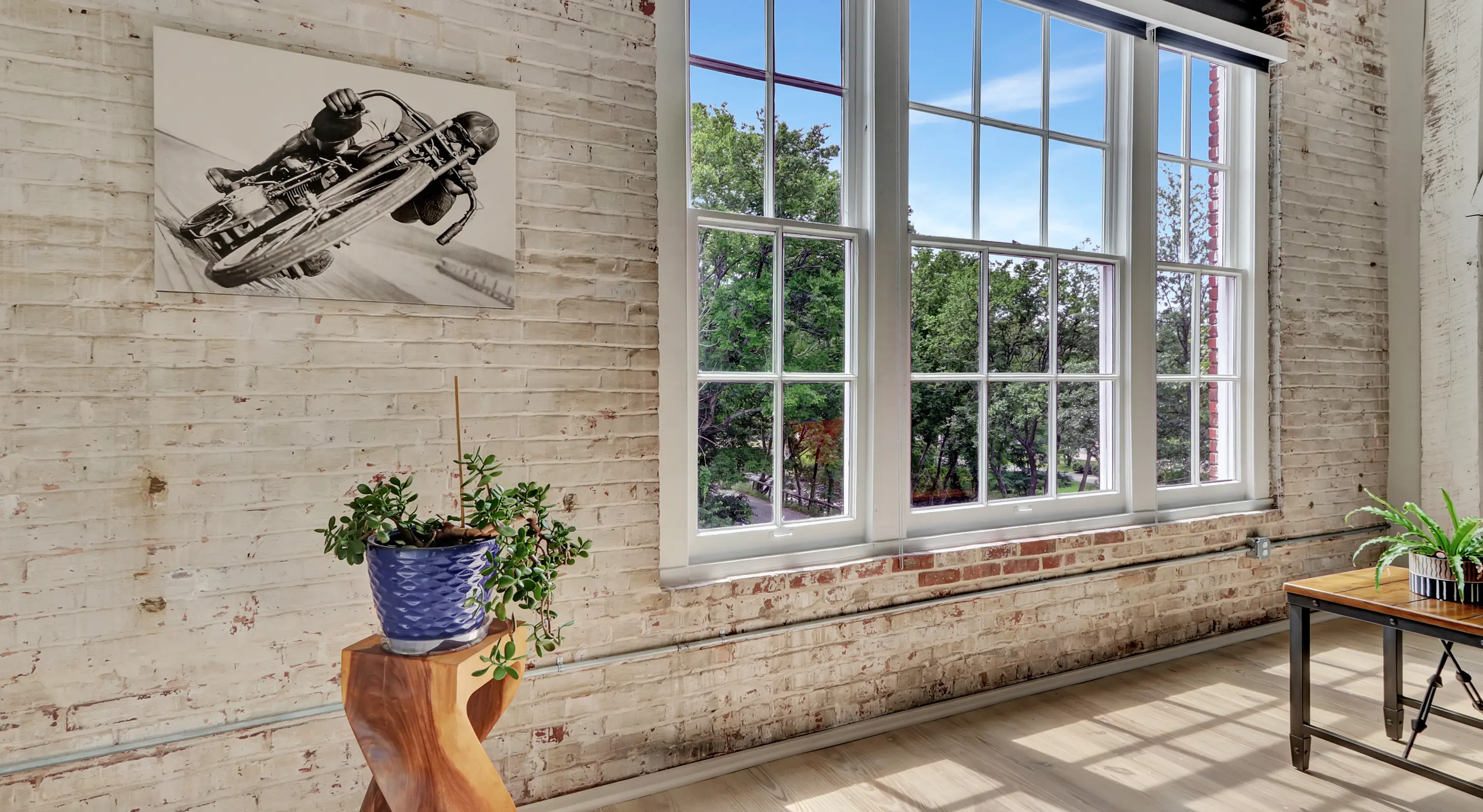 Large loft-style window with exposed brick and greenery views Downtown Hot Springs lodging