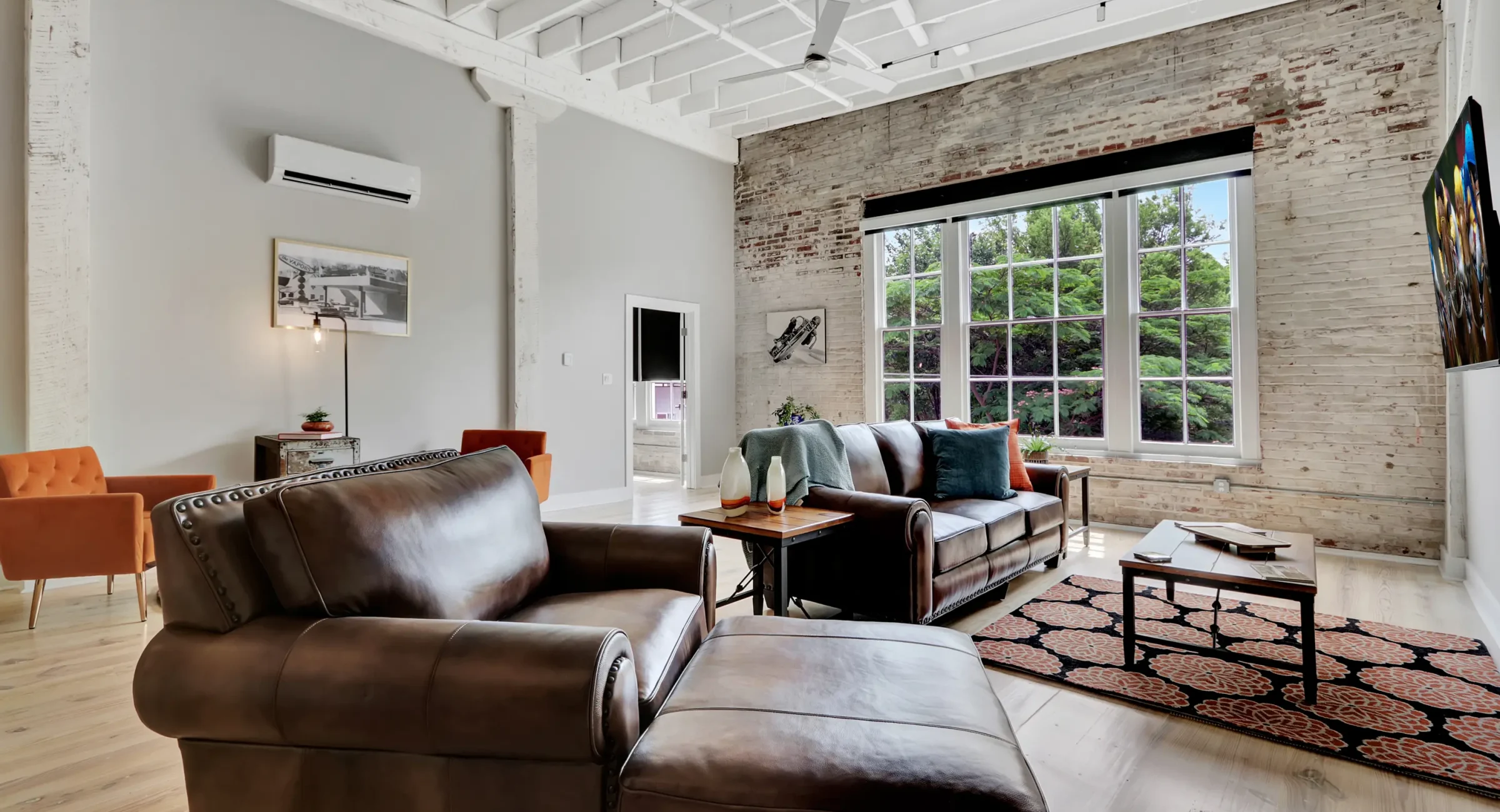 Bright living room with exposed brick and large picture windows Hot Springs National Park lodging