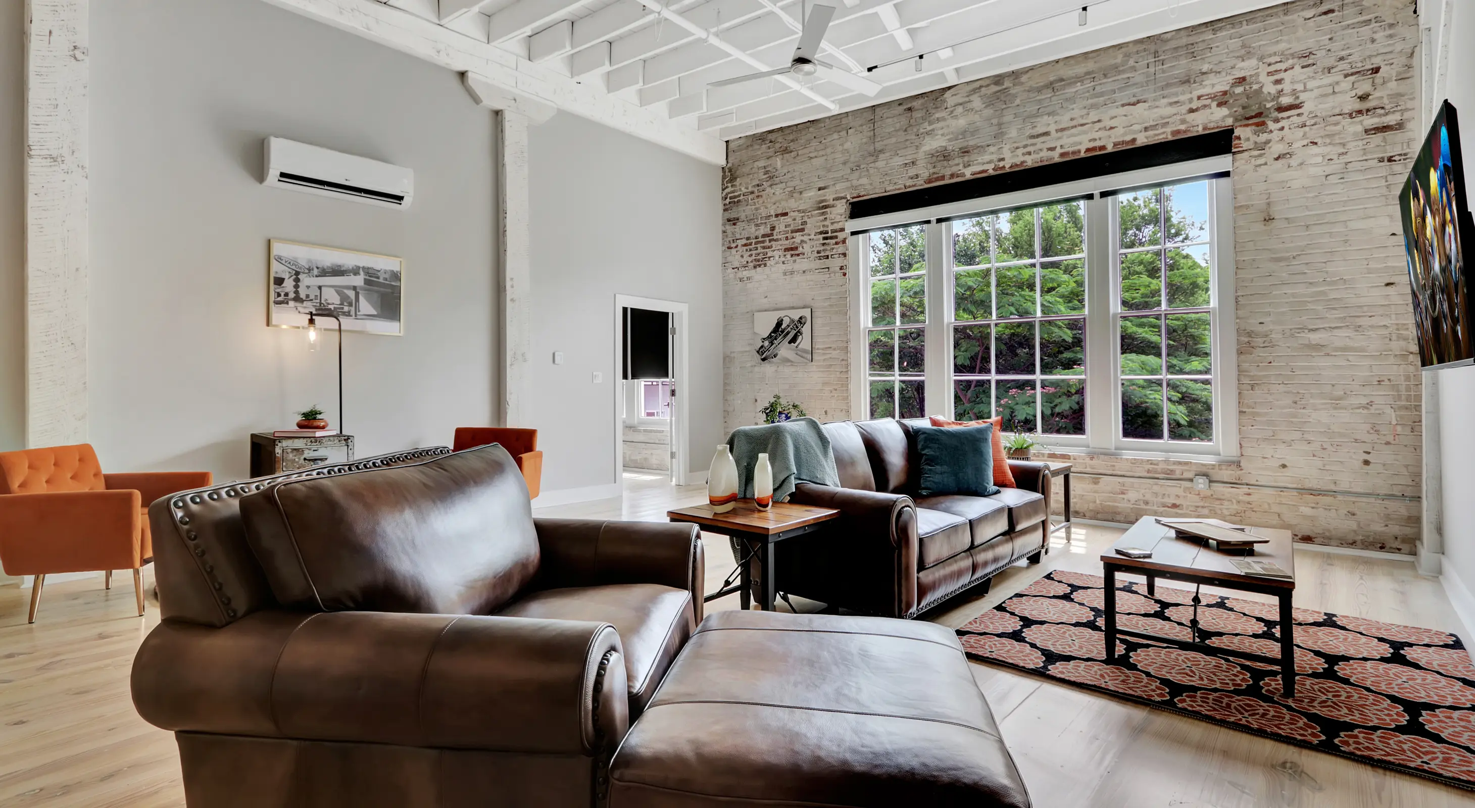 Bright living room with exposed brick and large picture windows Hot Springs National Park lodging