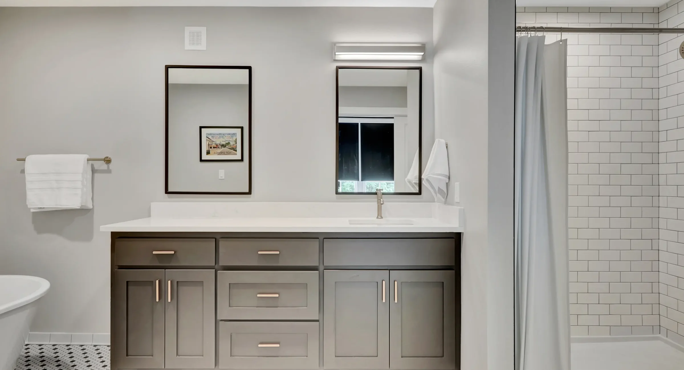 Double-vanity bathroom with subway-tile shower at lodging near Central Avenue Hot Springs