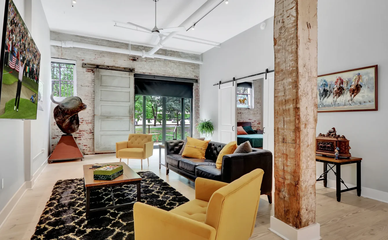 Spacious living area in a Hot Springs loft stay featuring exposed brick, eclectic décor, and comfortable seating