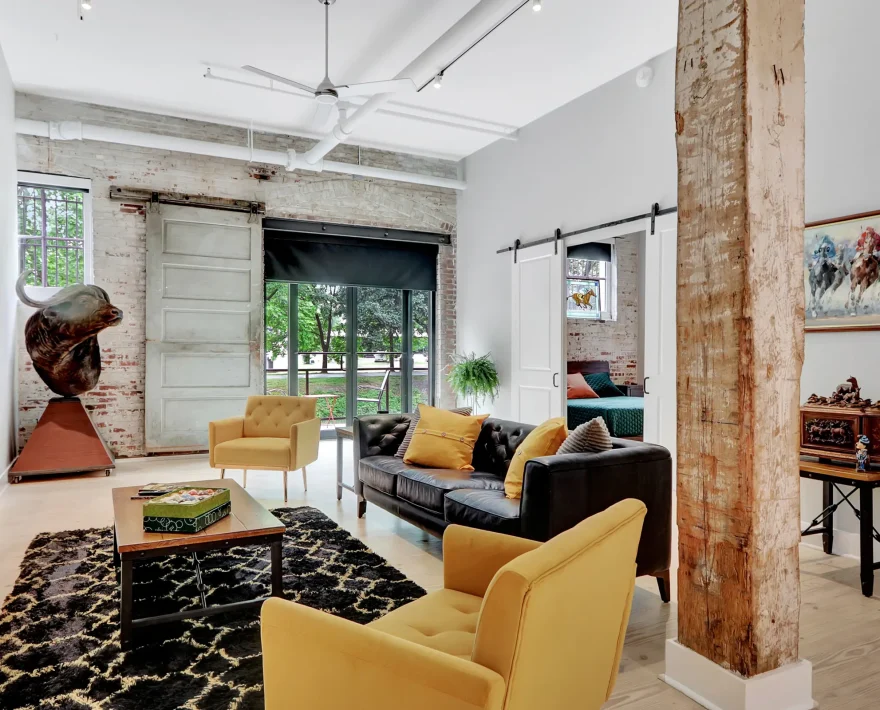 Spacious living area in a Hot Springs loft stay featuring exposed brick, eclectic décor, and comfortable seating