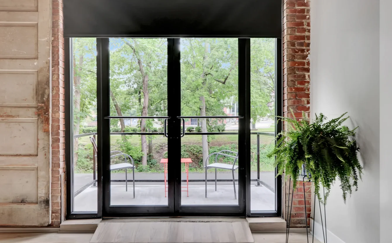 Glass doors leading to a small balcony with park views at a downtown Hot Springs loft accommodation