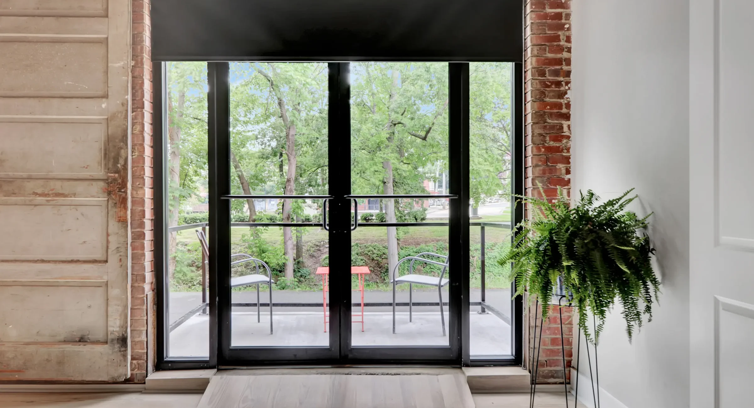 Glass doors leading to a small balcony with park views at a downtown Hot Springs loft accommodation