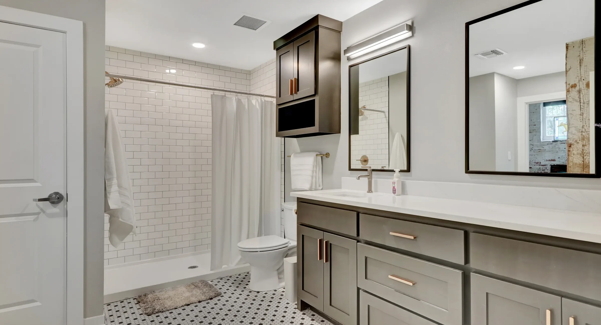 Spacious bathroom with subway-tile shower, storage cabinetry, and a large vanity inside a boutique loft stay in Hot Springs