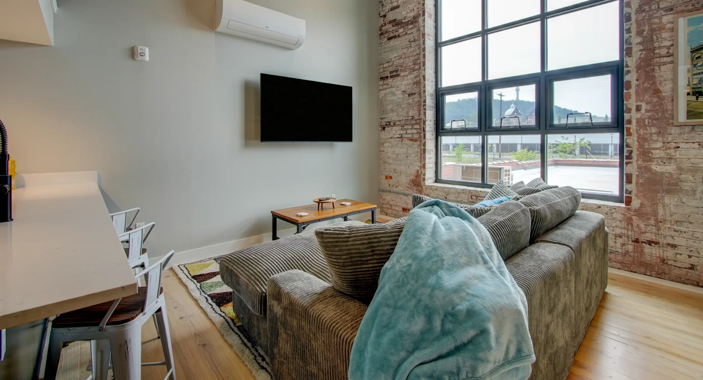 Open living area with exposed brick and large windows at downtown lodging near Hot Springs National Park
