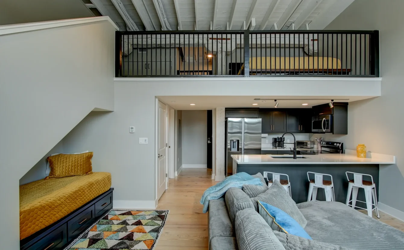 Loft-style living space with mezzanine bedroom and full kitchen at a downtown Arkansas boutique stay
