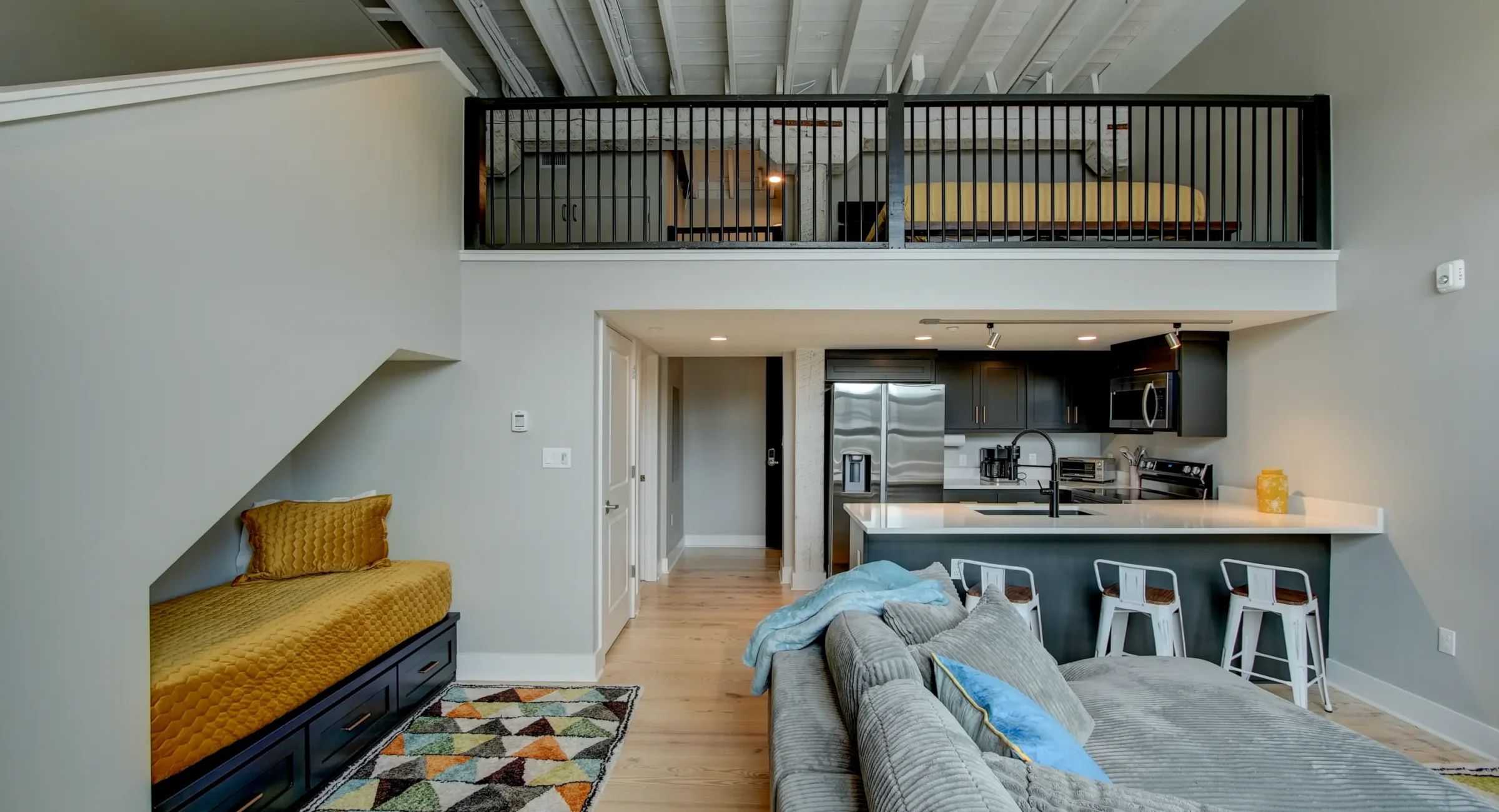 Loft-style living space with mezzanine bedroom and full kitchen at a downtown Arkansas boutique stay