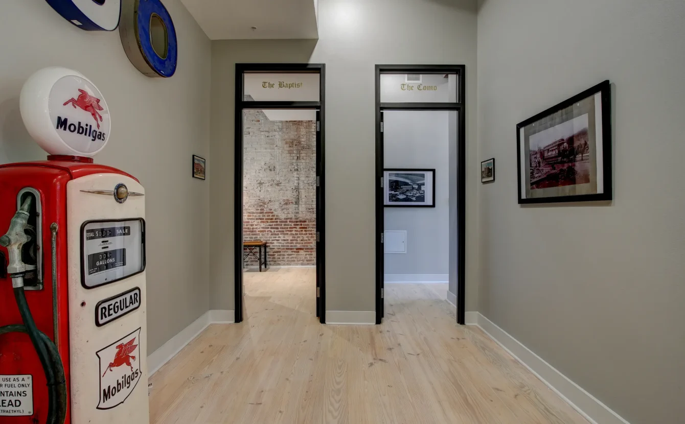 Hallway in a historic Hot Springs lodging building with unit entrances and vintage Mobilgas décor