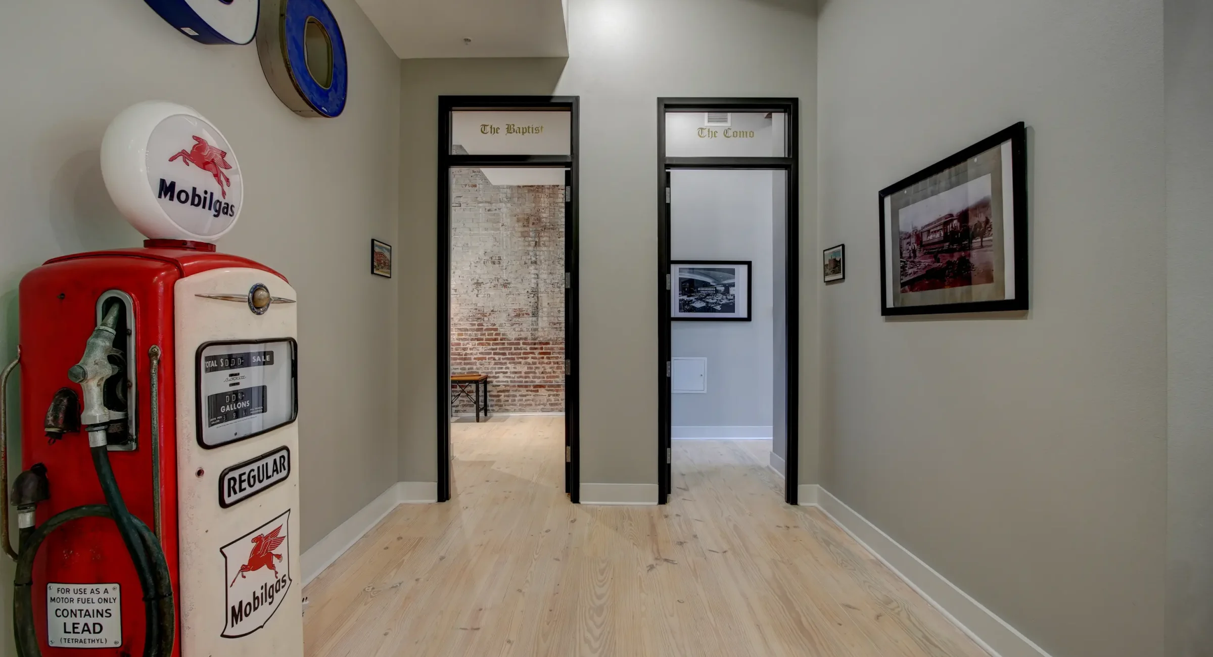 Hallway in a historic Hot Springs lodging building with unit entrances and vintage Mobilgas décor