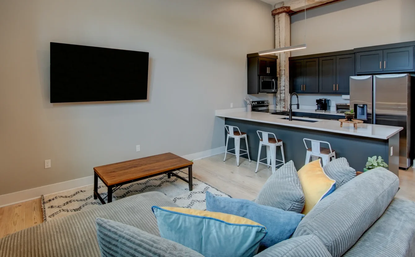 Open-concept Hot Springs accommodation with a modern kitchen, seating area, and exposed architectural elements