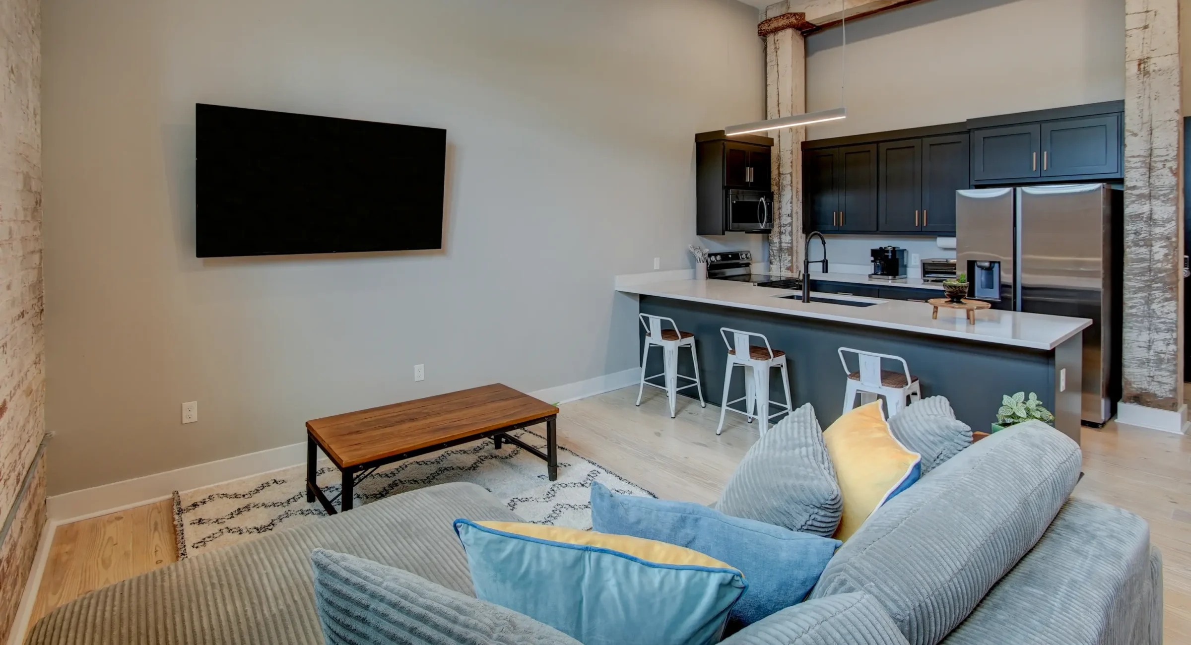 Open-concept Hot Springs accommodation with a modern kitchen, seating area, and exposed architectural elements