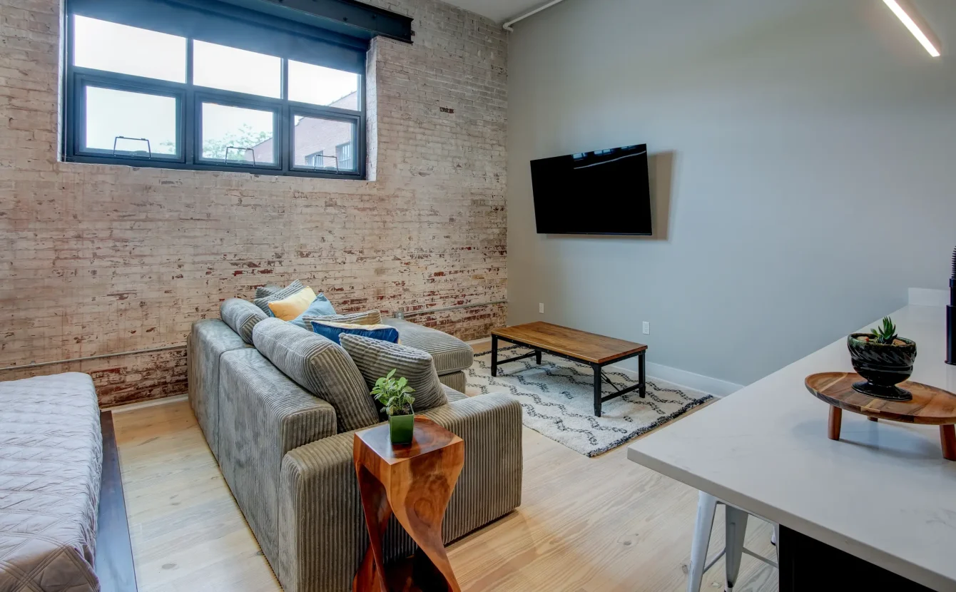 Studio-style Hot Springs lodging with exposed brick, cozy seating, and natural light from large windows