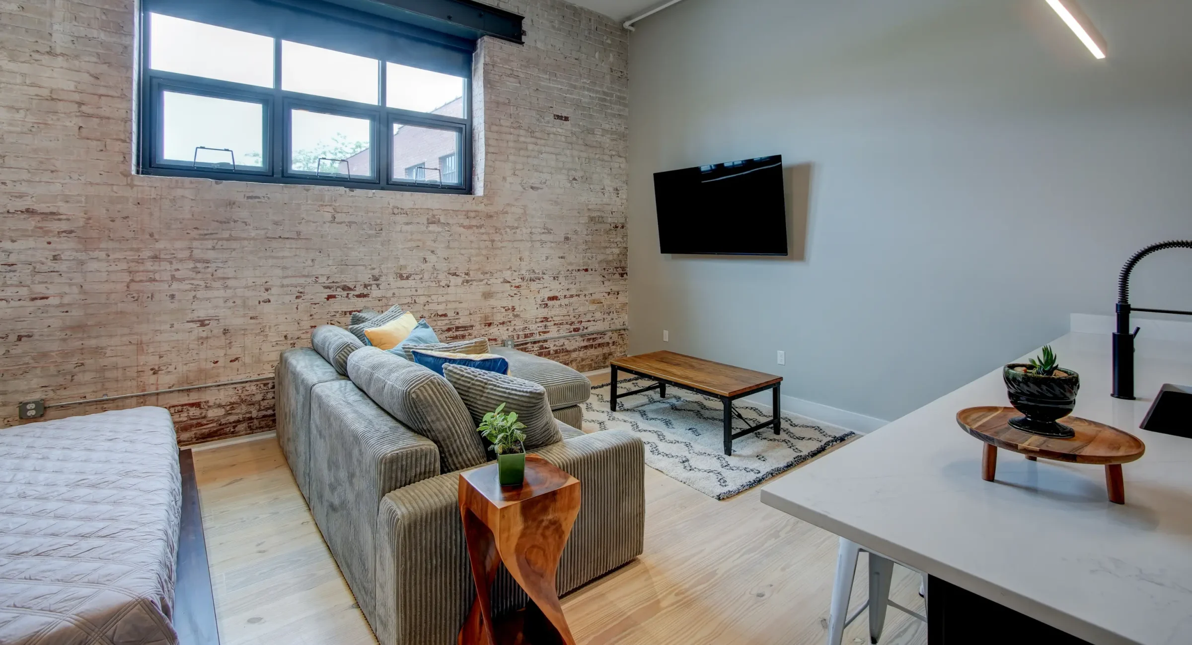 Studio-style Hot Springs lodging with exposed brick, cozy seating, and natural light from large windows