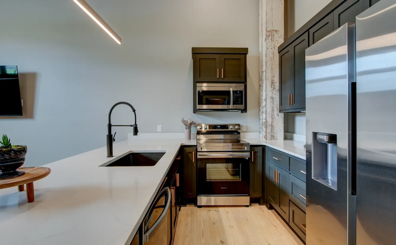 Kitchen detail inside a boutique Hot Springs stay with quartz counters, dark cabinets, and stainless appliances