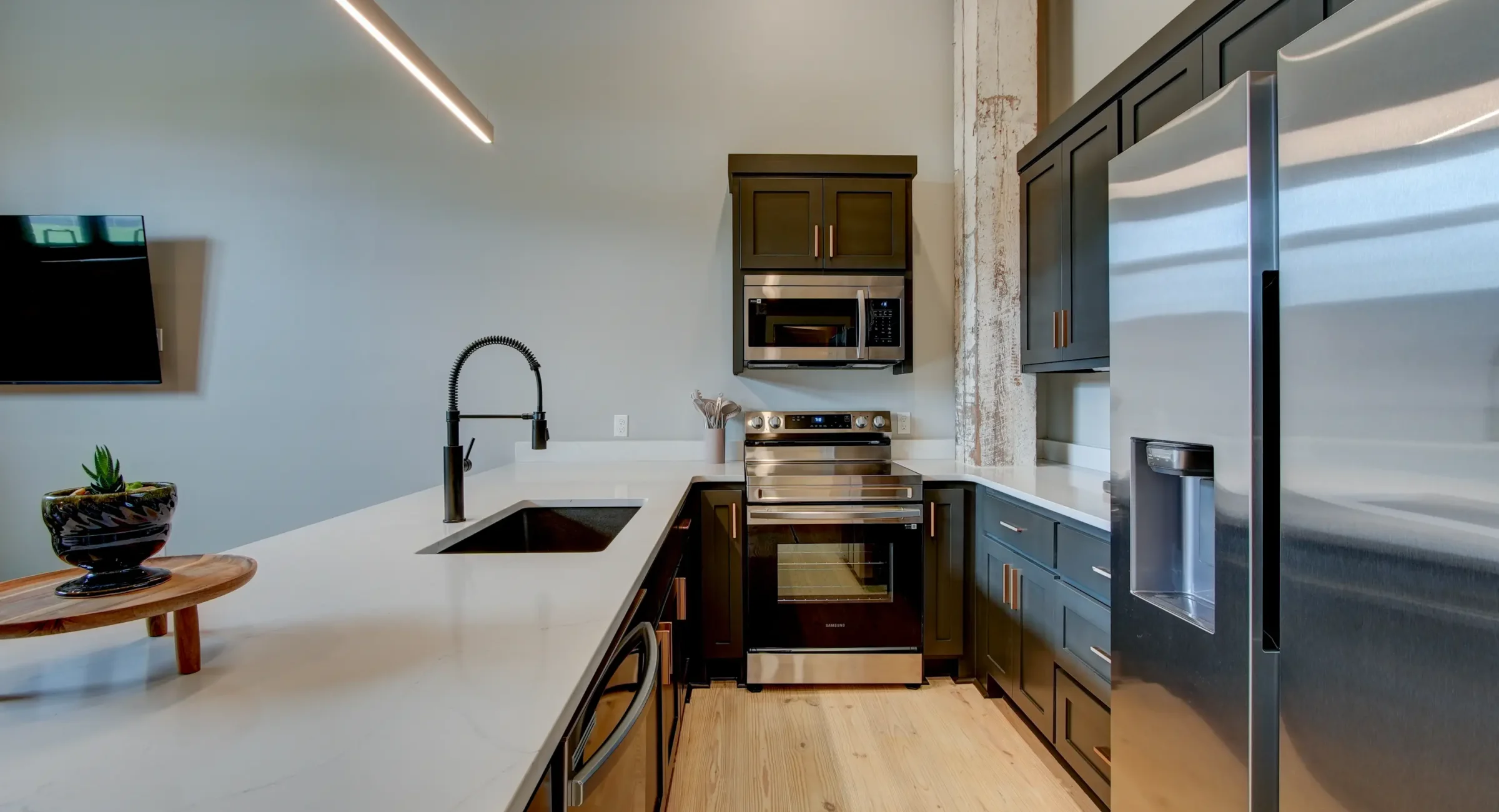 Kitchen detail inside a boutique Hot Springs stay with quartz counters, dark cabinets, and stainless appliances