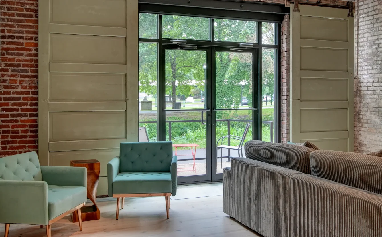 Bright sitting area in a Hot Springs loft rental with tall sliding doors opening to park views