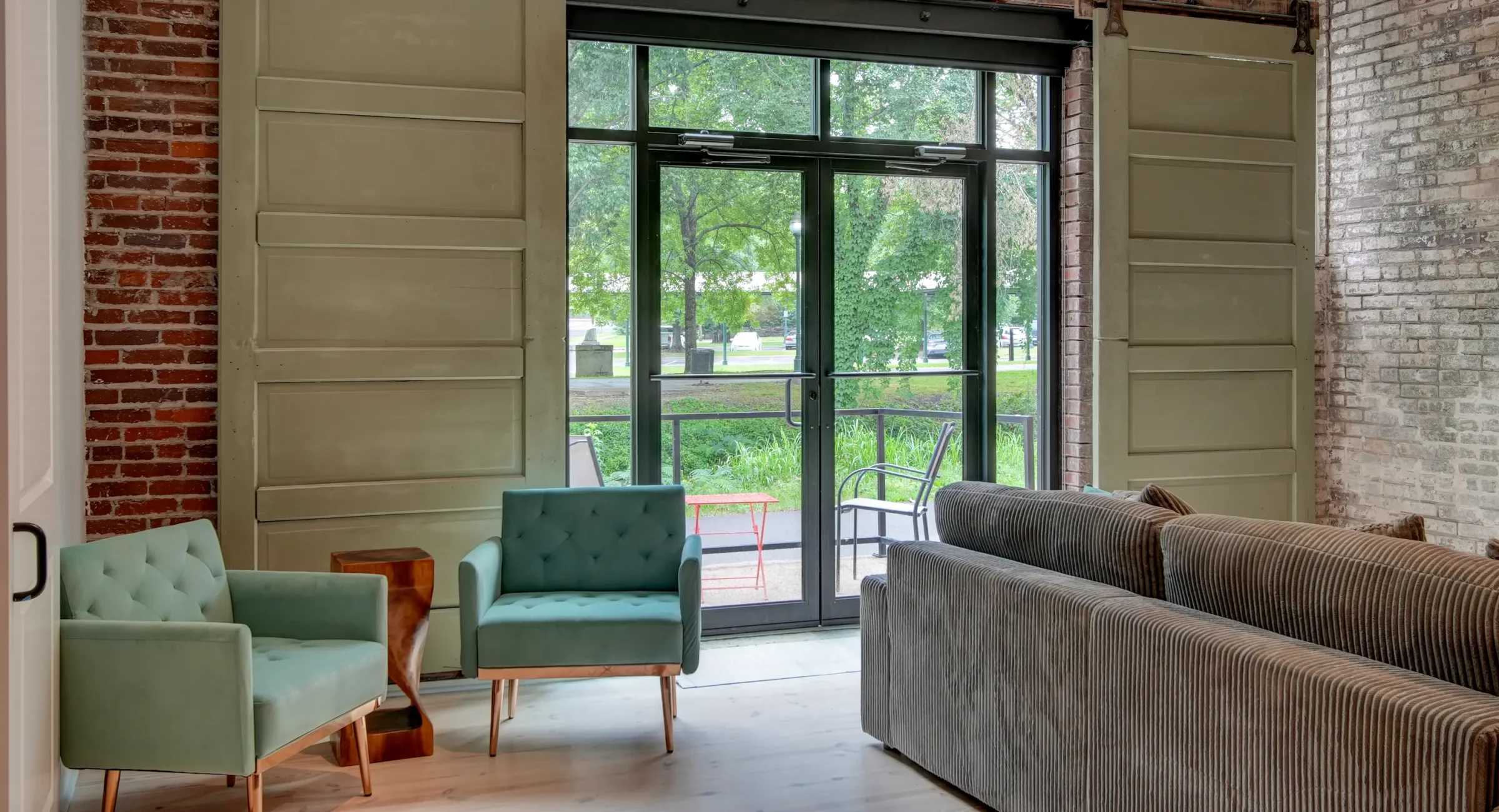 Bright sitting area in a Hot Springs loft rental with tall sliding doors opening to park views