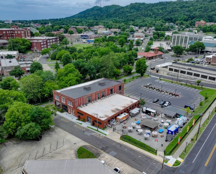Aerial view of the boutique loft-style property, nearby historic buildings, and the Hot Springs mountain backdrop