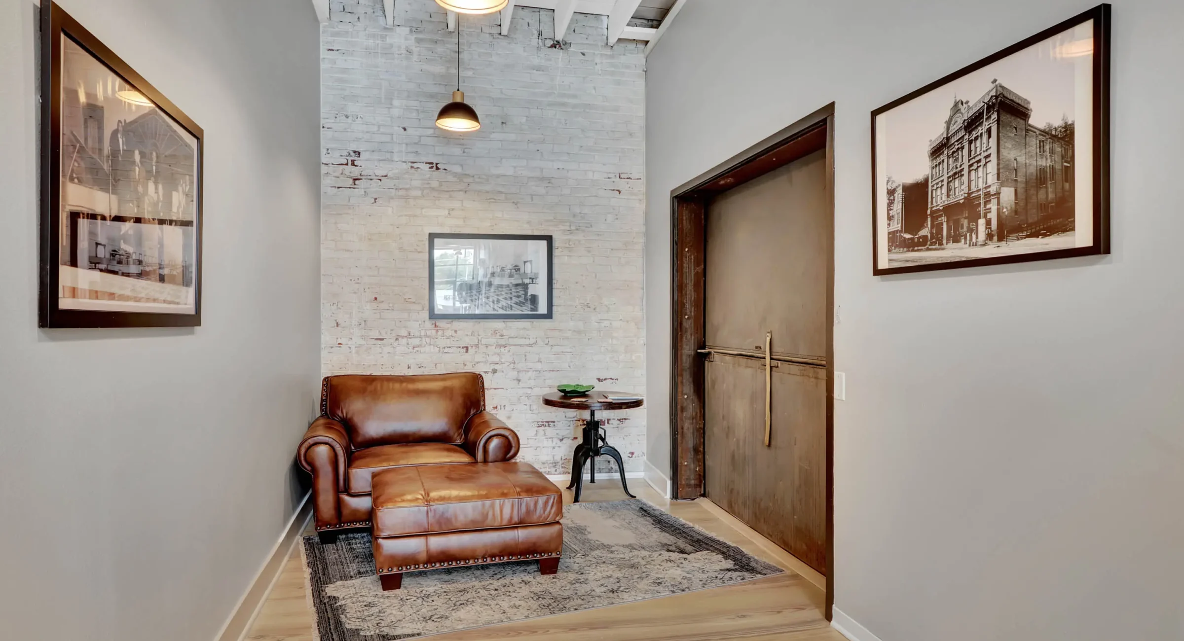 Brick-walled foyer with historic Hot Springs photography and leather seating