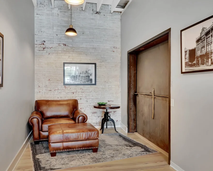 Brick-walled foyer with historic Hot Springs photography and leather seating