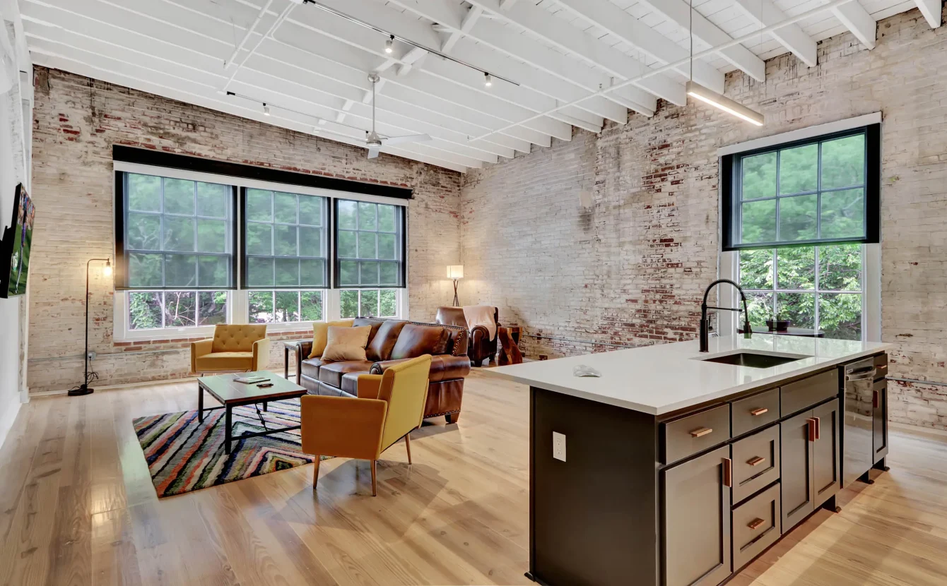 Open-concept loft living space with exposed brick and modern kitchen in Hot Springs