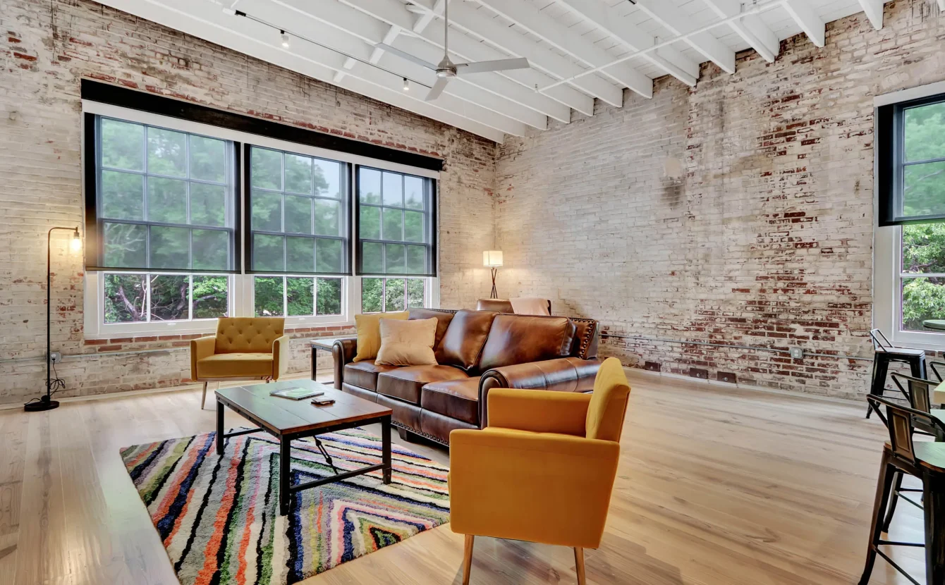 Spacious living area with exposed brick and oversized windows in downtown Hot Springs