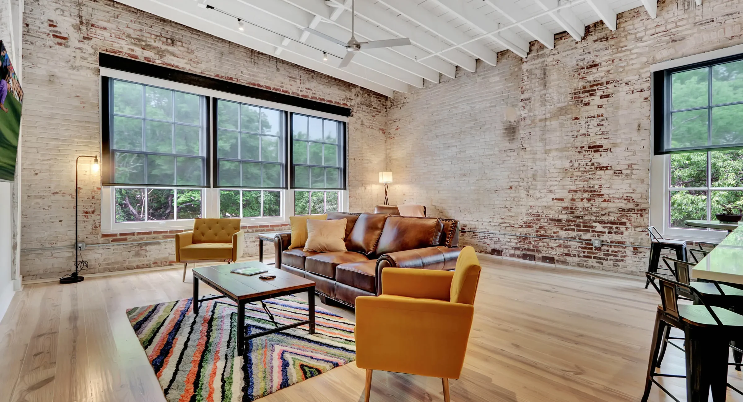 Spacious living area with exposed brick and oversized windows in downtown Hot Springs