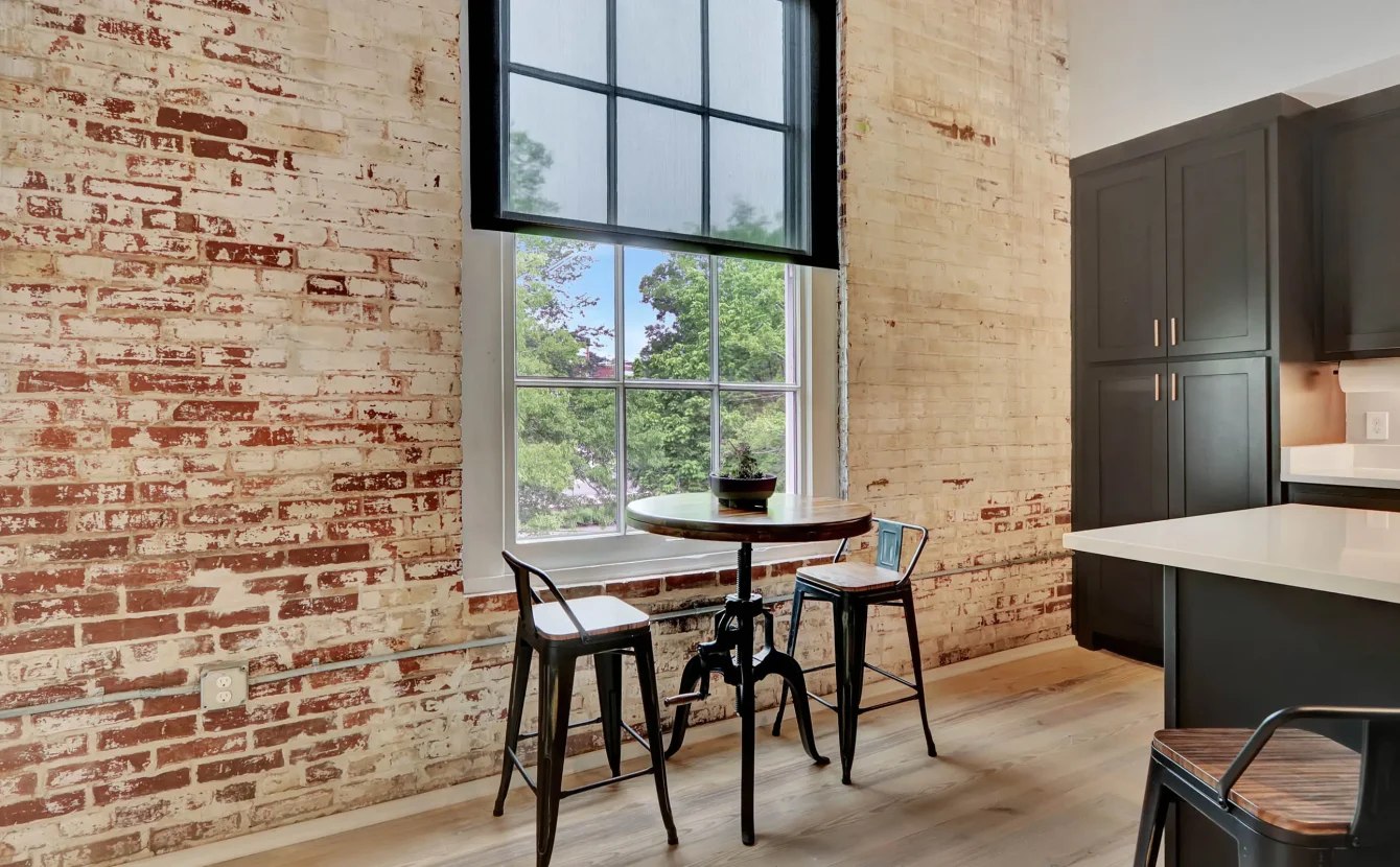 Bistro seating by original brick wall and large window in downtown Hot Spring