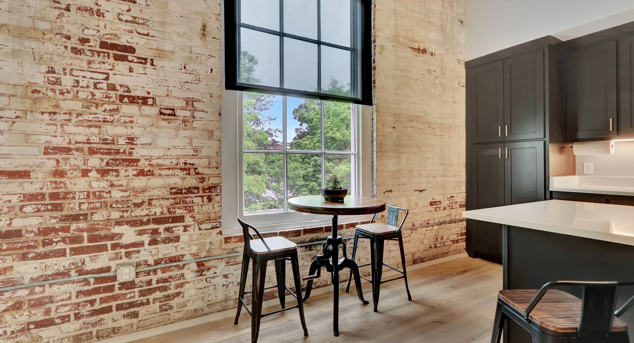 Bistro seating by original brick wall and large window in downtown Hot Spring