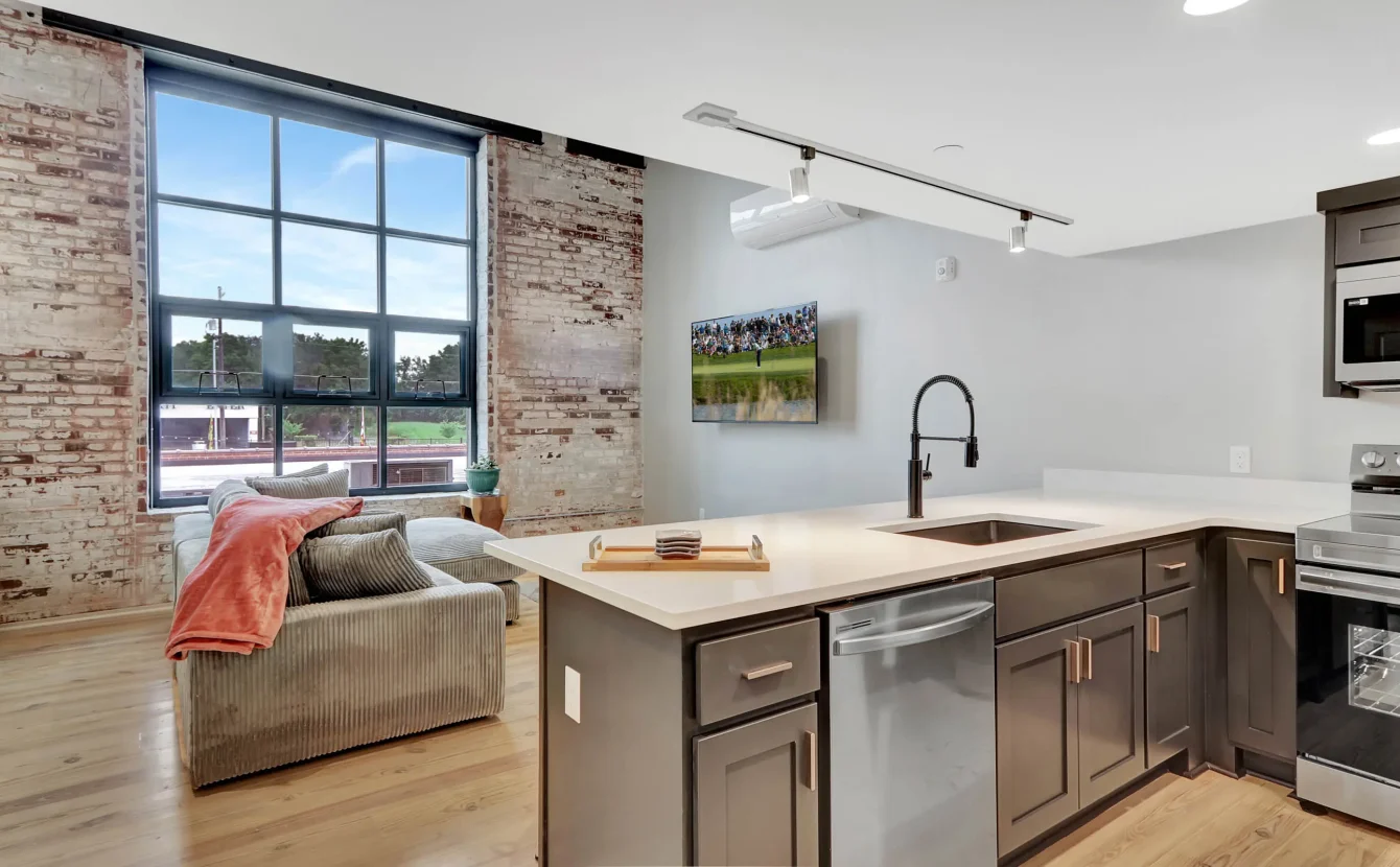 Open kitchen and living area with exposed brick in downtown Hot Springs loft