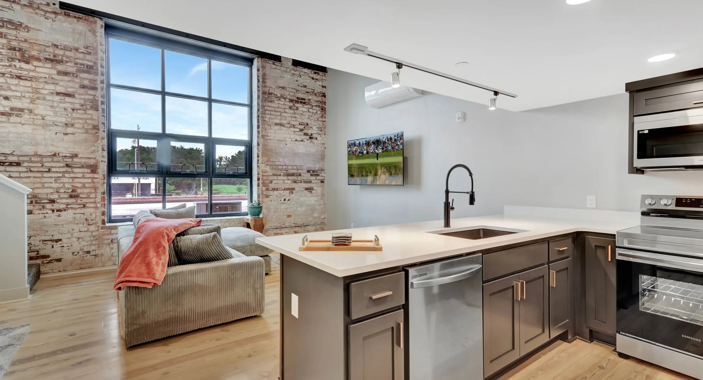 Open kitchen and living area with exposed brick in downtown Hot Springs loft