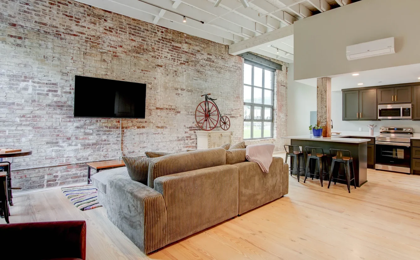 Loft living room with exposed brick walls and large windows