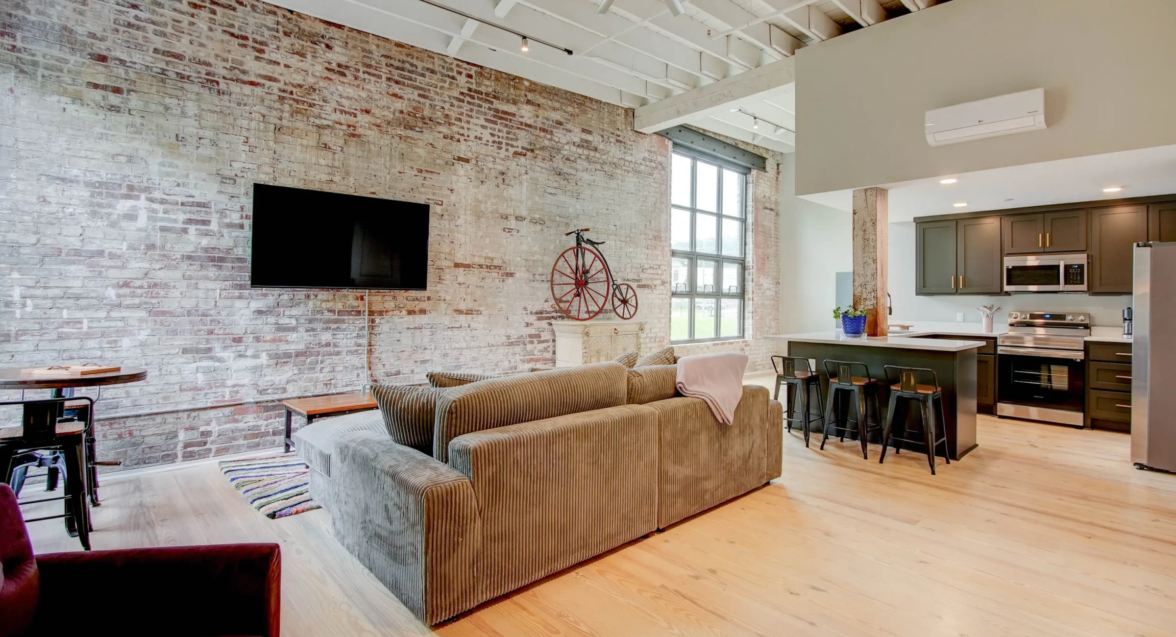 Loft living room with exposed brick walls and large windows