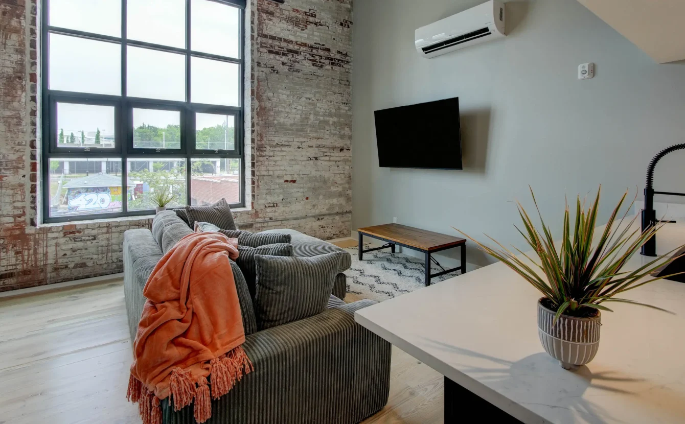 Living area with brick walls and large windows in downtown Hot Springs loft
