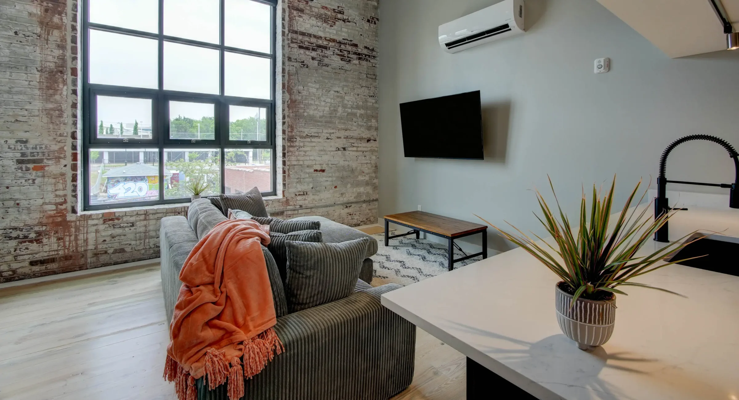 Living area with brick walls and large windows in downtown Hot Springs loft