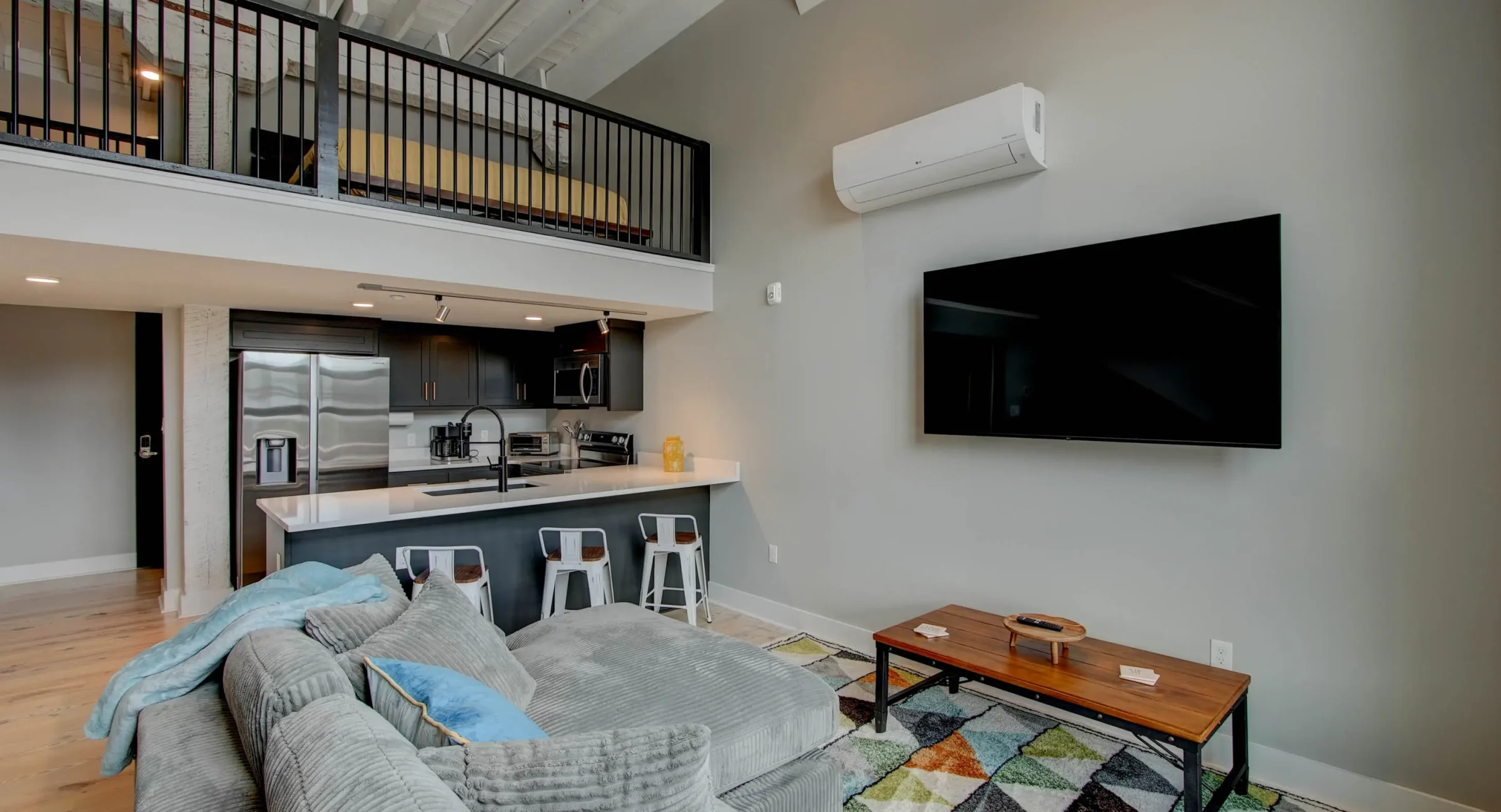 Open loft bedroom overlooking living area in downtown Hot Springs accommodations