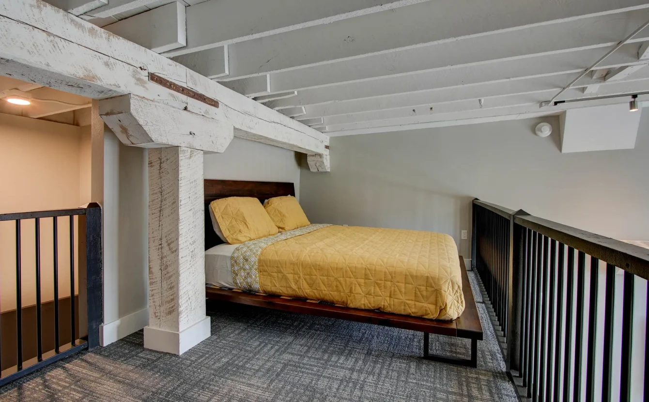Open loft bedroom overlooking living area in downtown Hot Springs accommodations