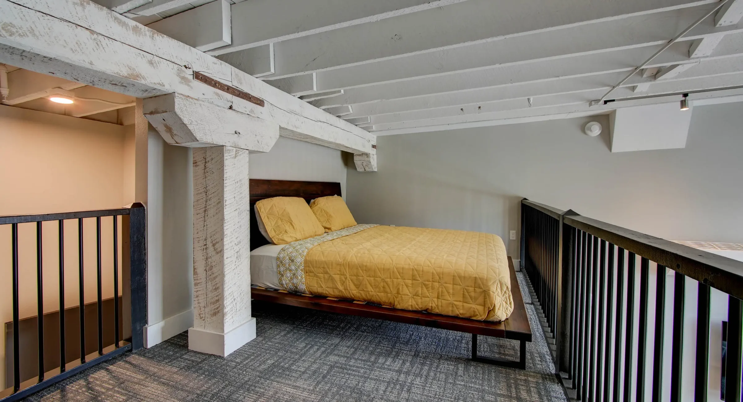 Open loft bedroom overlooking living area in downtown Hot Springs accommodations