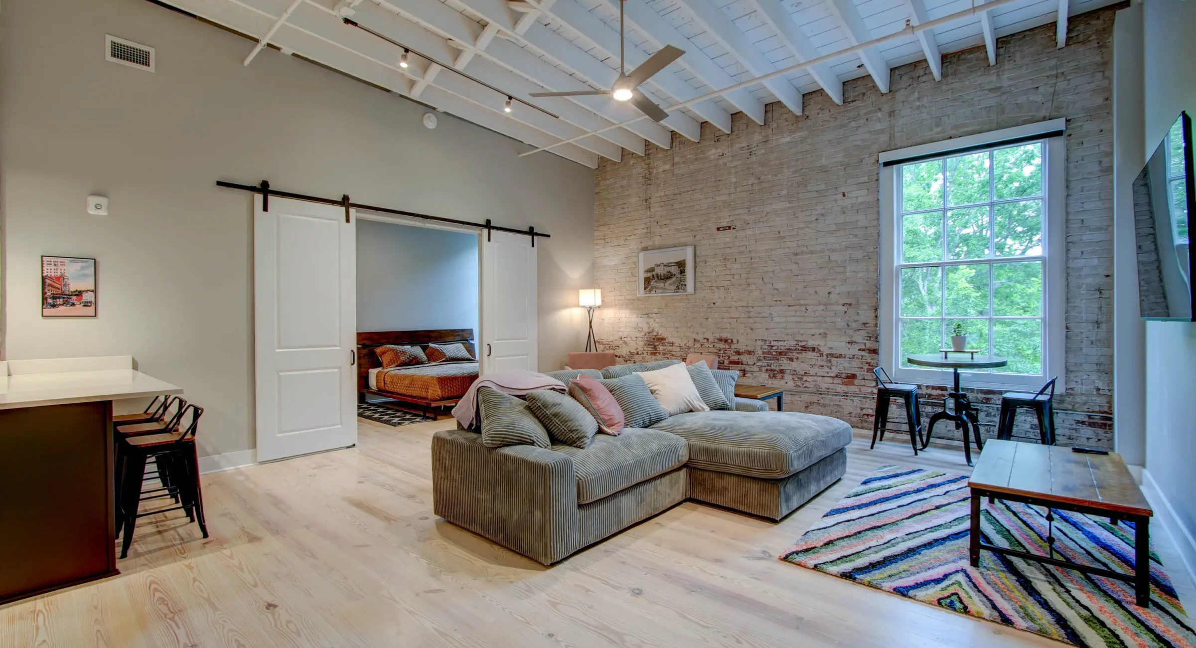 Open-concept living room with exposed brick in The Moody suite, Hot Springs