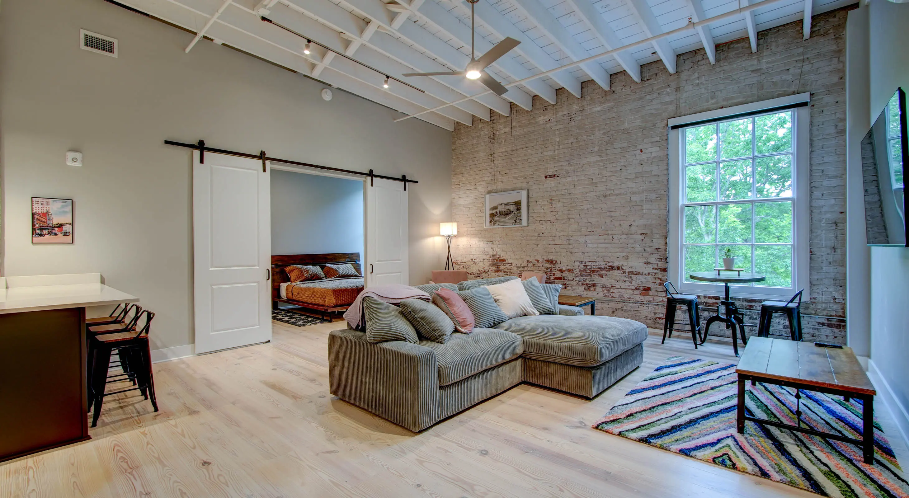 Open-concept living room with exposed brick in The Moody suite, Hot Springs